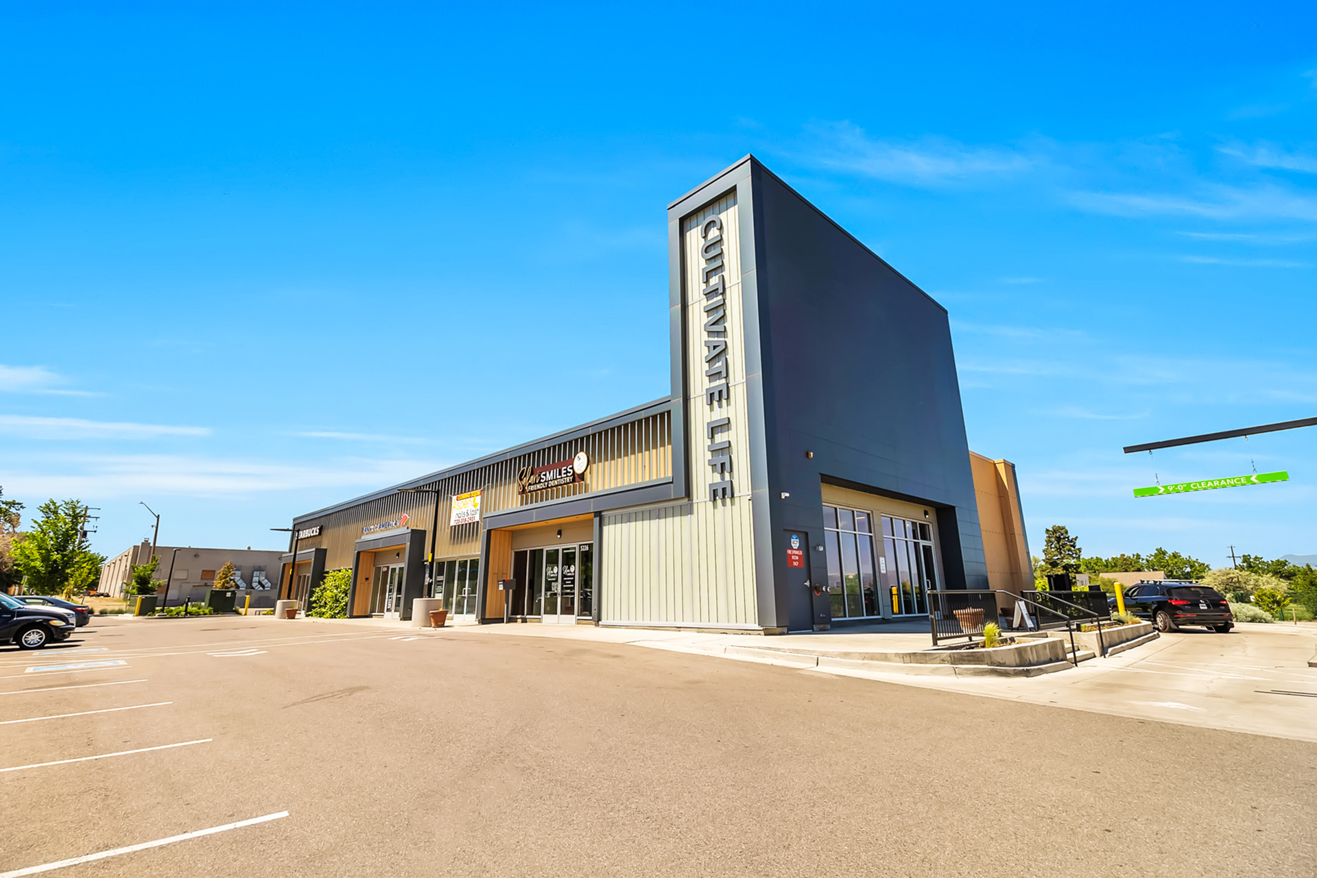 The image shows a modern building with a flat roof, large windows, and a sign that reads  CASINO.  It is situated in a parking lot with a clear blue sky above.