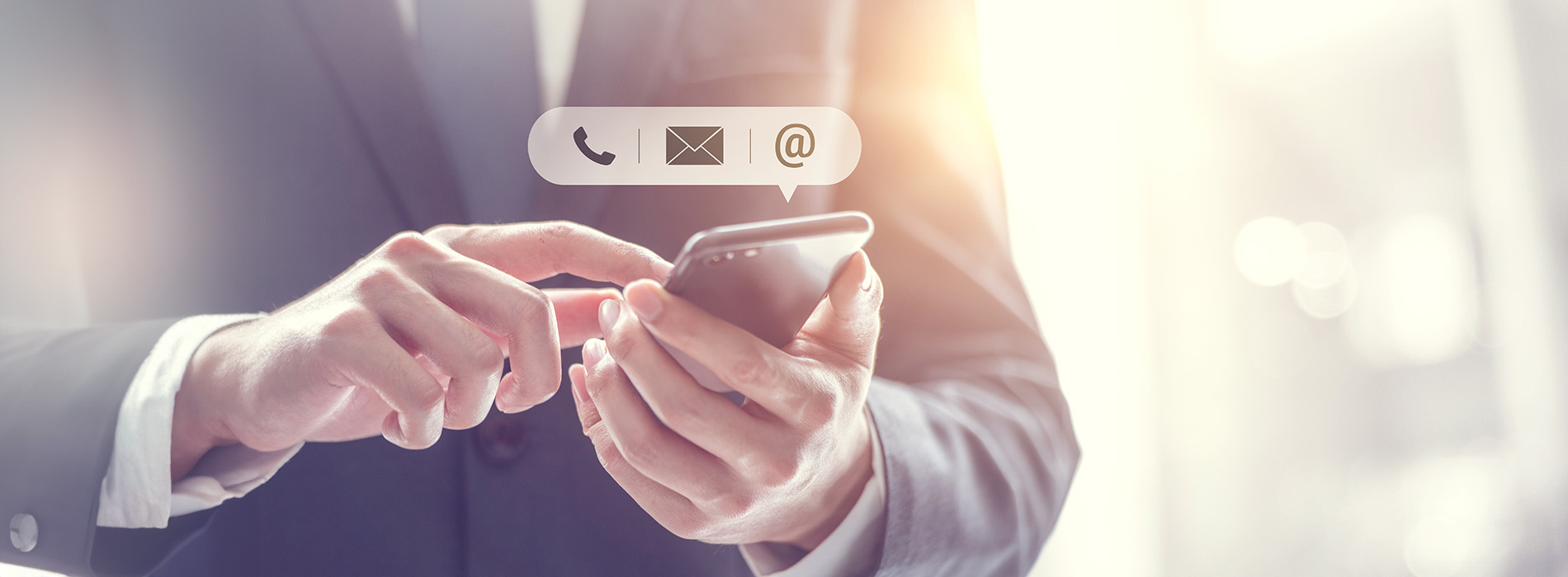 The image shows a person s hands holding a smartphone, with the screen displaying an email app and the background featuring a blurred office environment.