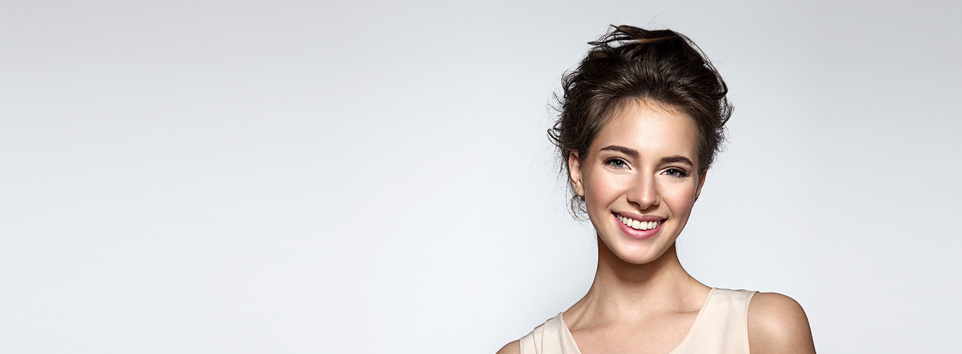 A woman with a radiant smile, set against a minimalist background.