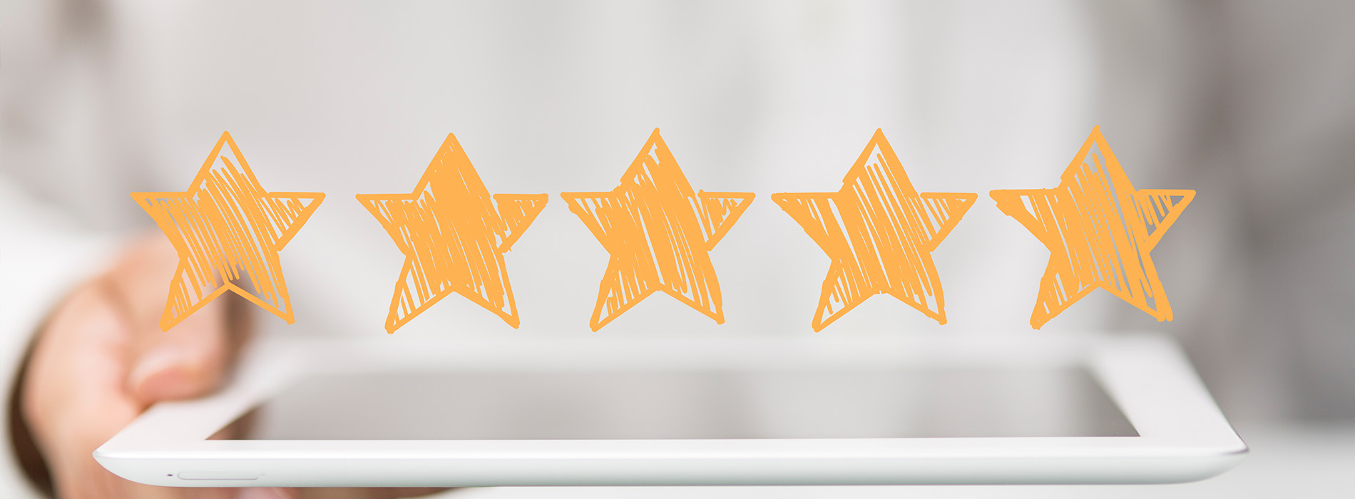 An image of a hand holding a tablet with a graphic of five stars, suggesting a rating or review system.