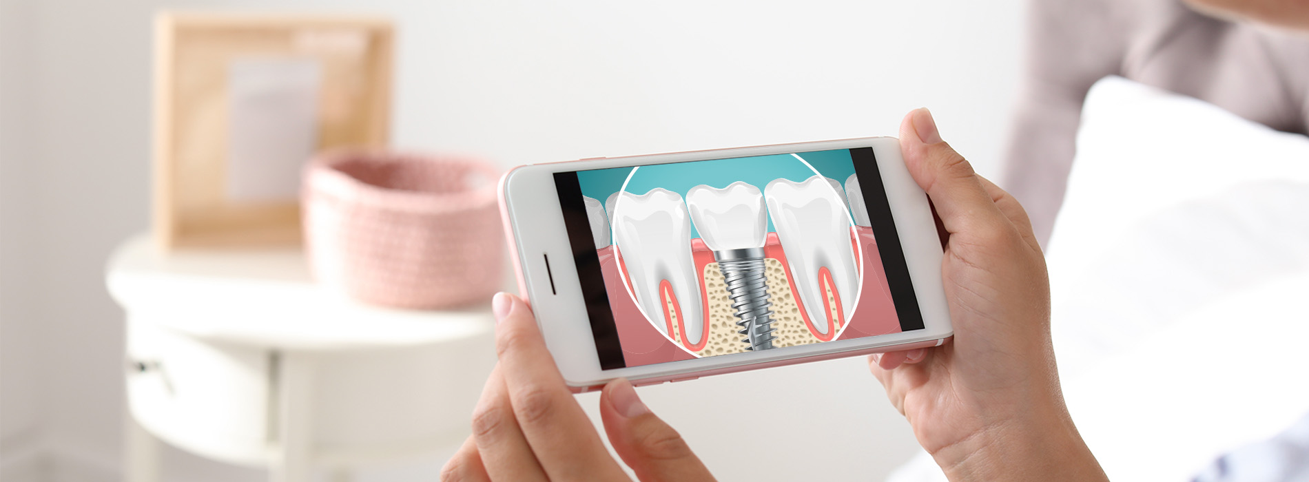 Hand holding a smartphone displaying an animated toothbrush cleaning teeth, with a blurred background of a room.