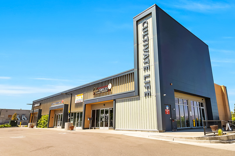 The image depicts a modern building with a sign that reads 'Cineplex' in front of it, suggesting it is a movie theater.