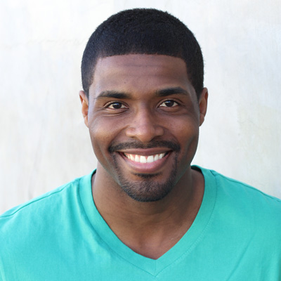 In the image, an elderly couple is sitting closely together, smiling and appearing to be in a joyful moment. They are outdoors, with a clear sky above them.