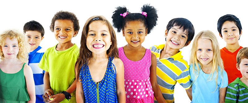 The image shows a diverse group of children and teenagers posing for a photo, with various expressions and clothing styles, against a plain background.