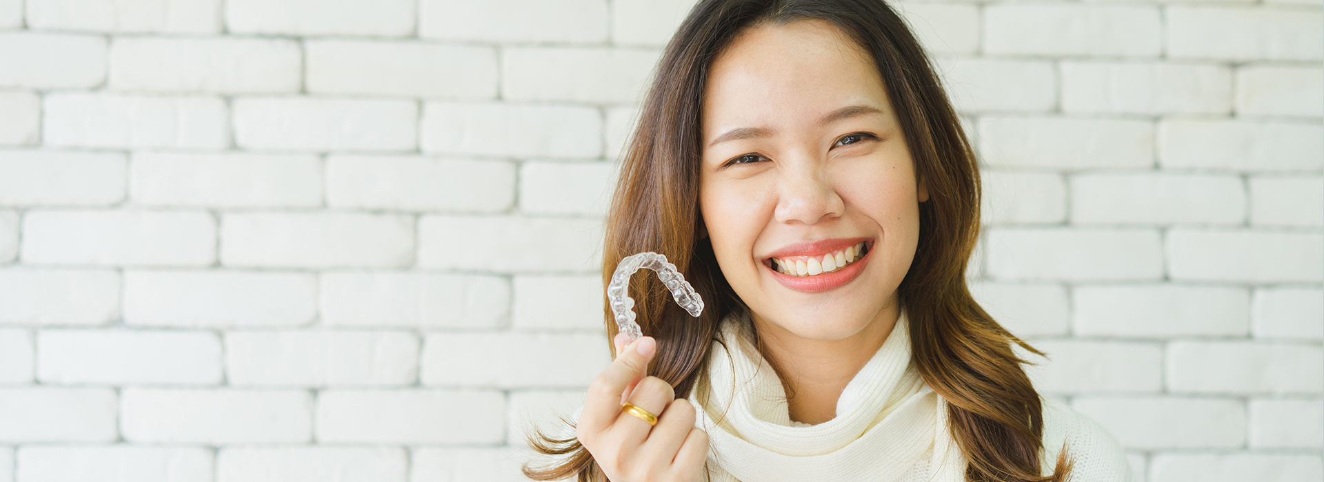 A cheerful woman wearing a ring, smiling at the camera.